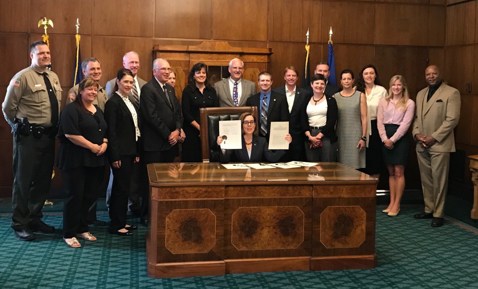 Governor Brown signs SB 1562 into law. Sr. DDA Skinner fourth from left.